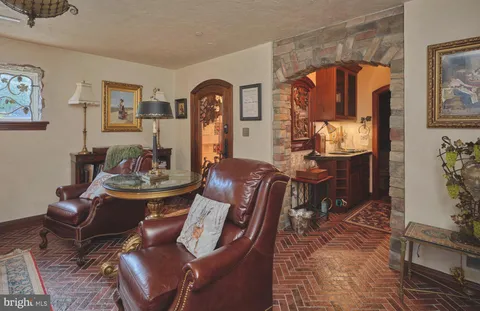 a living room with furniture a rug and wall painting