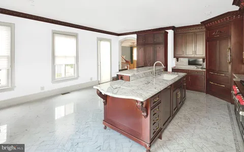 a kitchen with kitchen island granite countertop a sink stove and refrigerator
