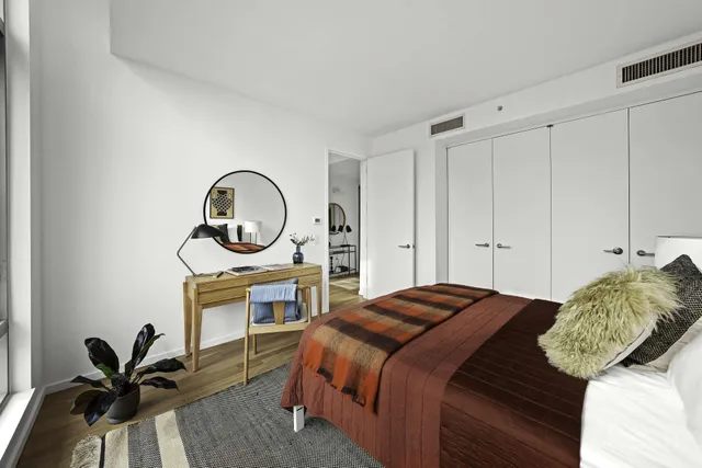 a bedroom with a bed and a lamp with wooden floor