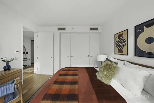 a bedroom with a bed a mirror and a table in it