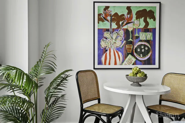 a bedroom with a bed and a lamp on dresser