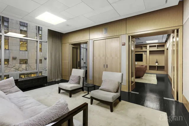 a living room with couches and a dining table with wooden floor