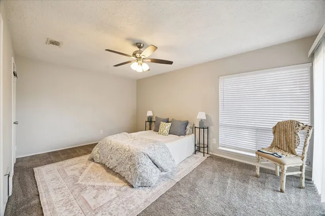 a bedroom with a bed chair and a window