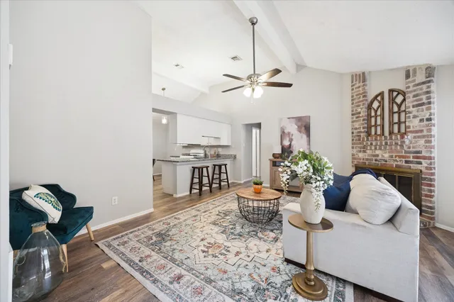 a living room with furniture a chandelier and a rug