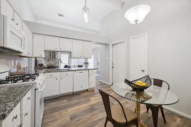 a kitchen with a table chairs stove and cabinets
