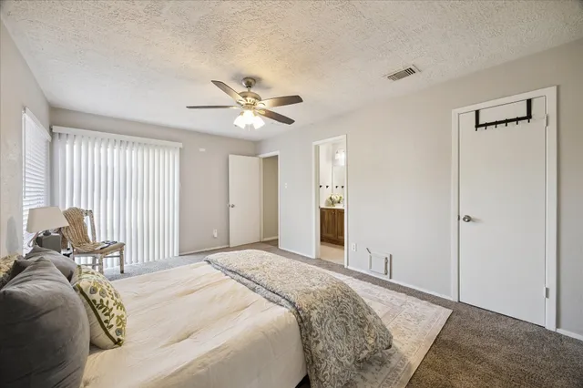 a spacious bedroom with a bed and a chandelier