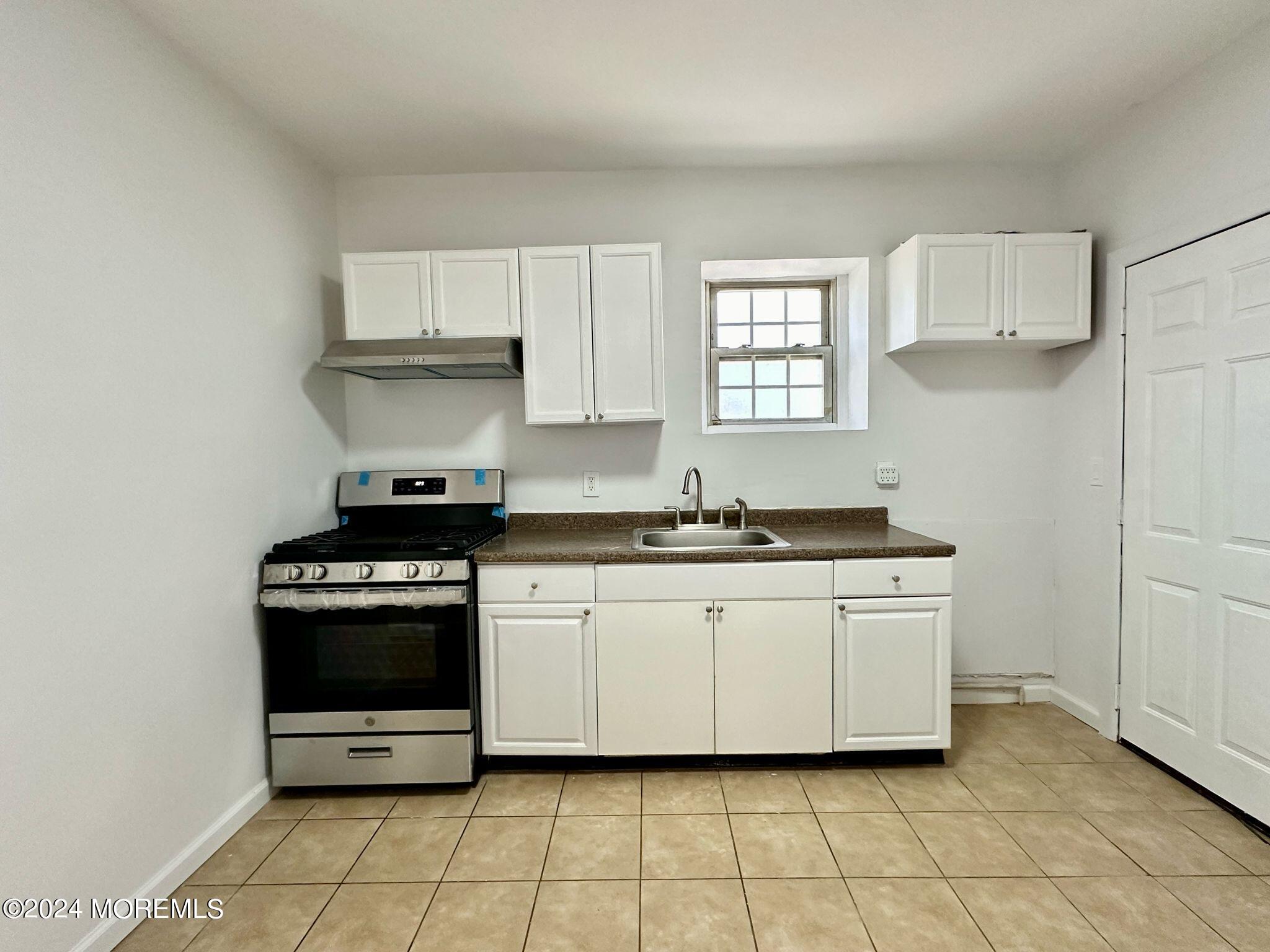 462 Compton Avenue, Unit THIRD Perth Amboy, NJ 08861 - Photo 13 of 14 a kitchen with stainless steel appliances granite countertop a stove a sink and a refrigerator