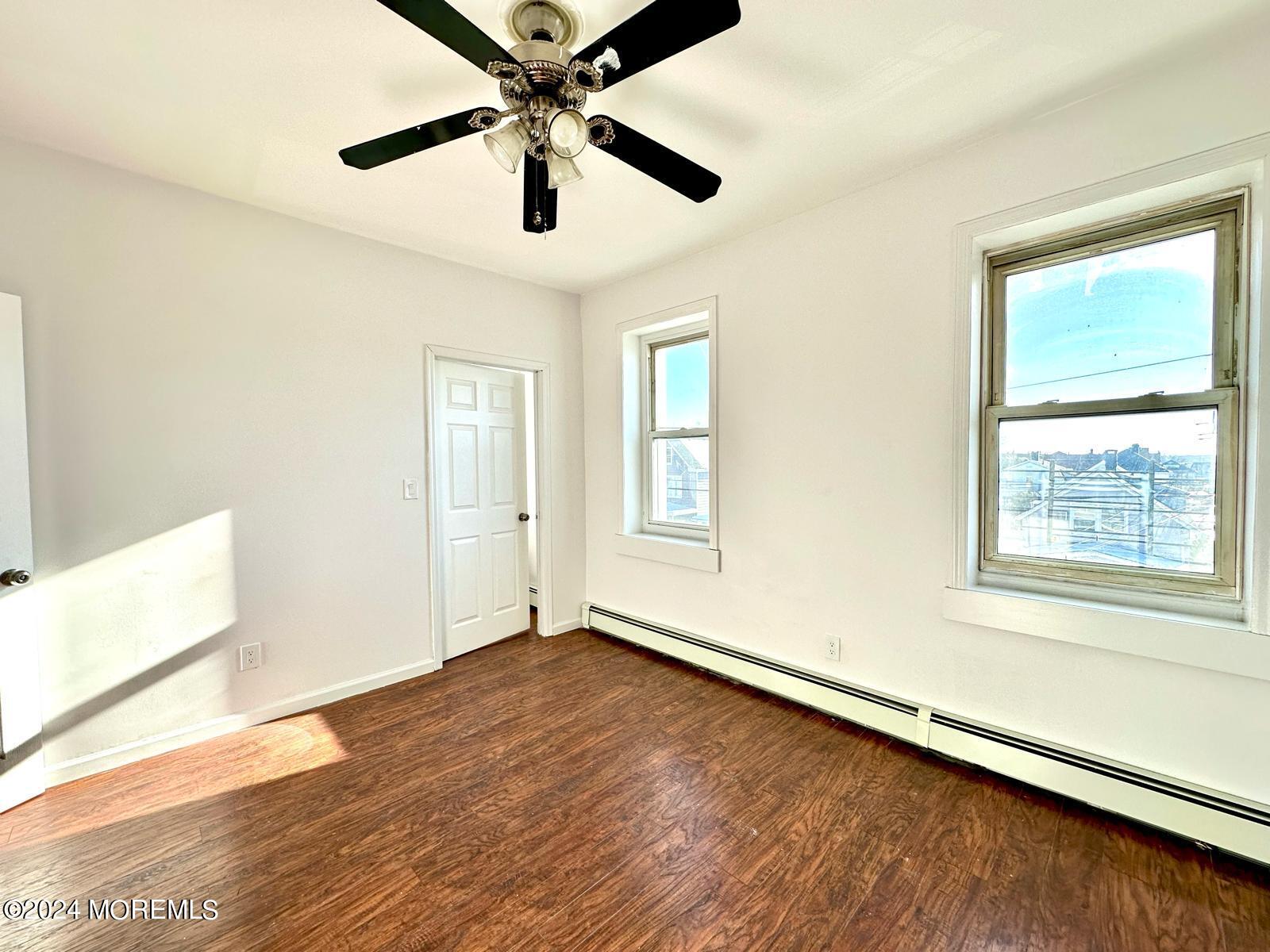 462 Compton Avenue, Unit THIRD Perth Amboy, NJ 08861 - Photo 2 of 14 a view of an empty room with wooden floor and a window