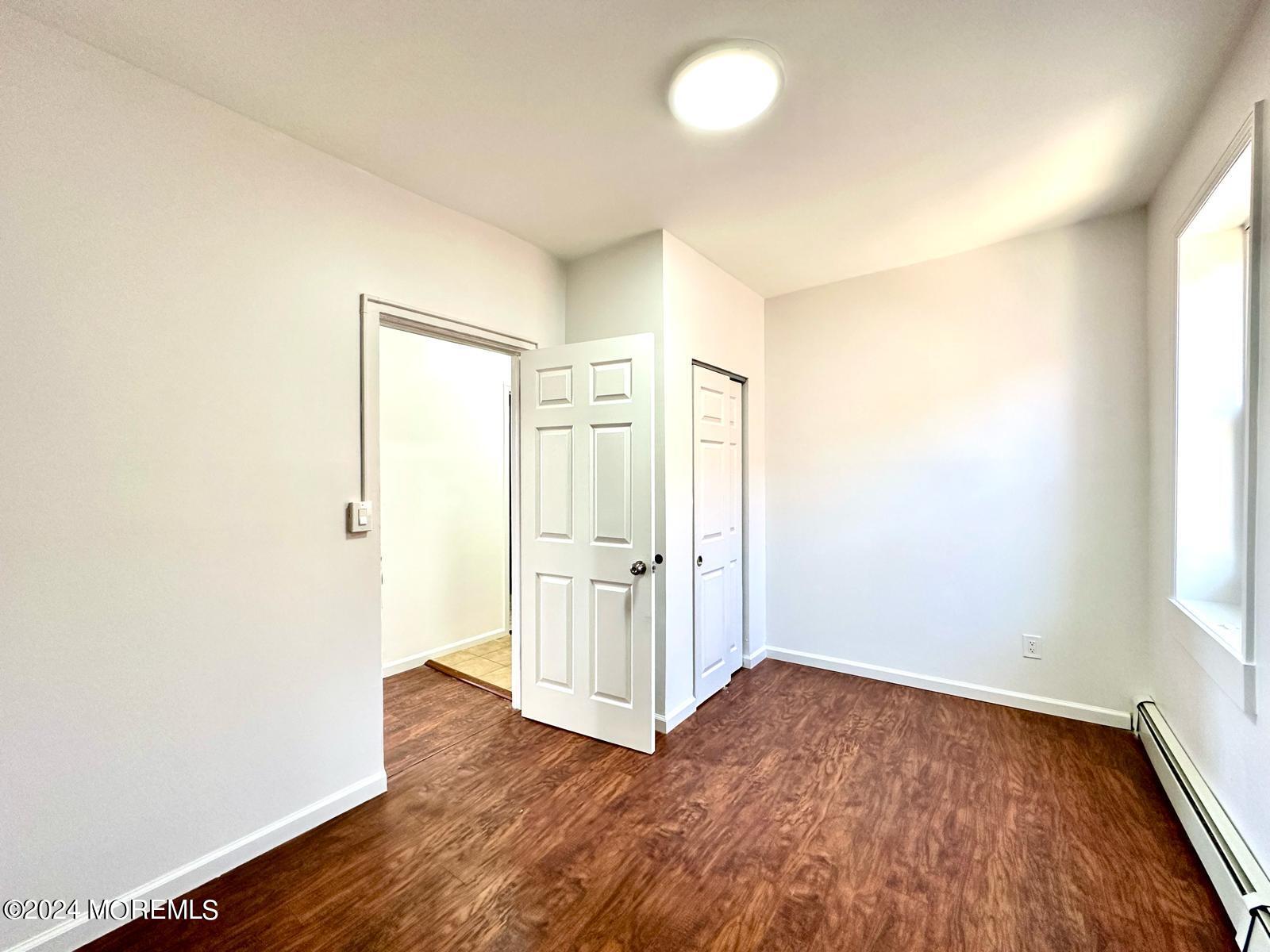 462 Compton Avenue, Unit THIRD Perth Amboy, NJ 08861 - Photo 5 of 14 an empty room with wooden floor and windows