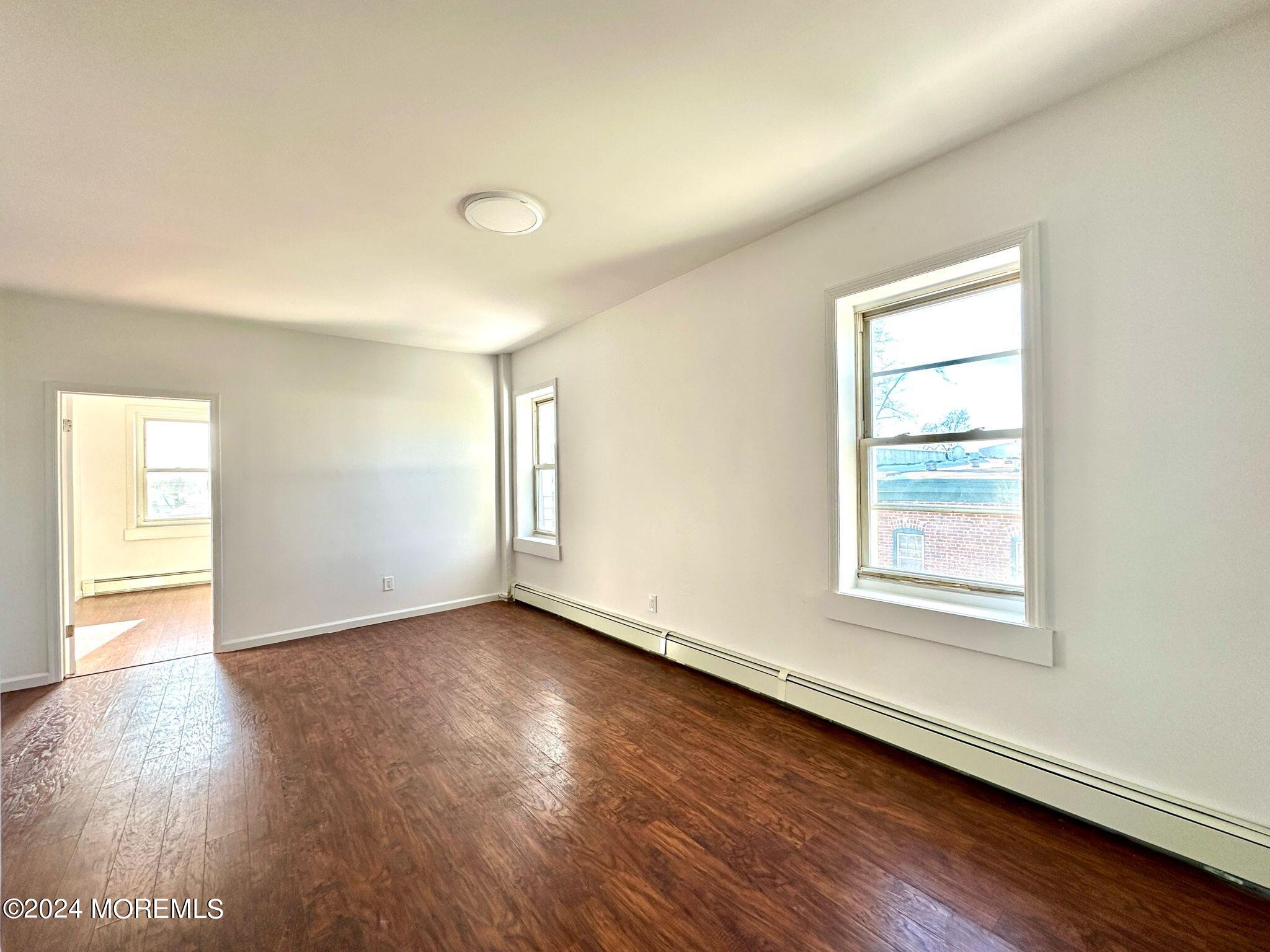 462 Compton Avenue, Unit THIRD Perth Amboy, NJ 08861 - Photo 6 of 14 an empty room with wooden floor and windows