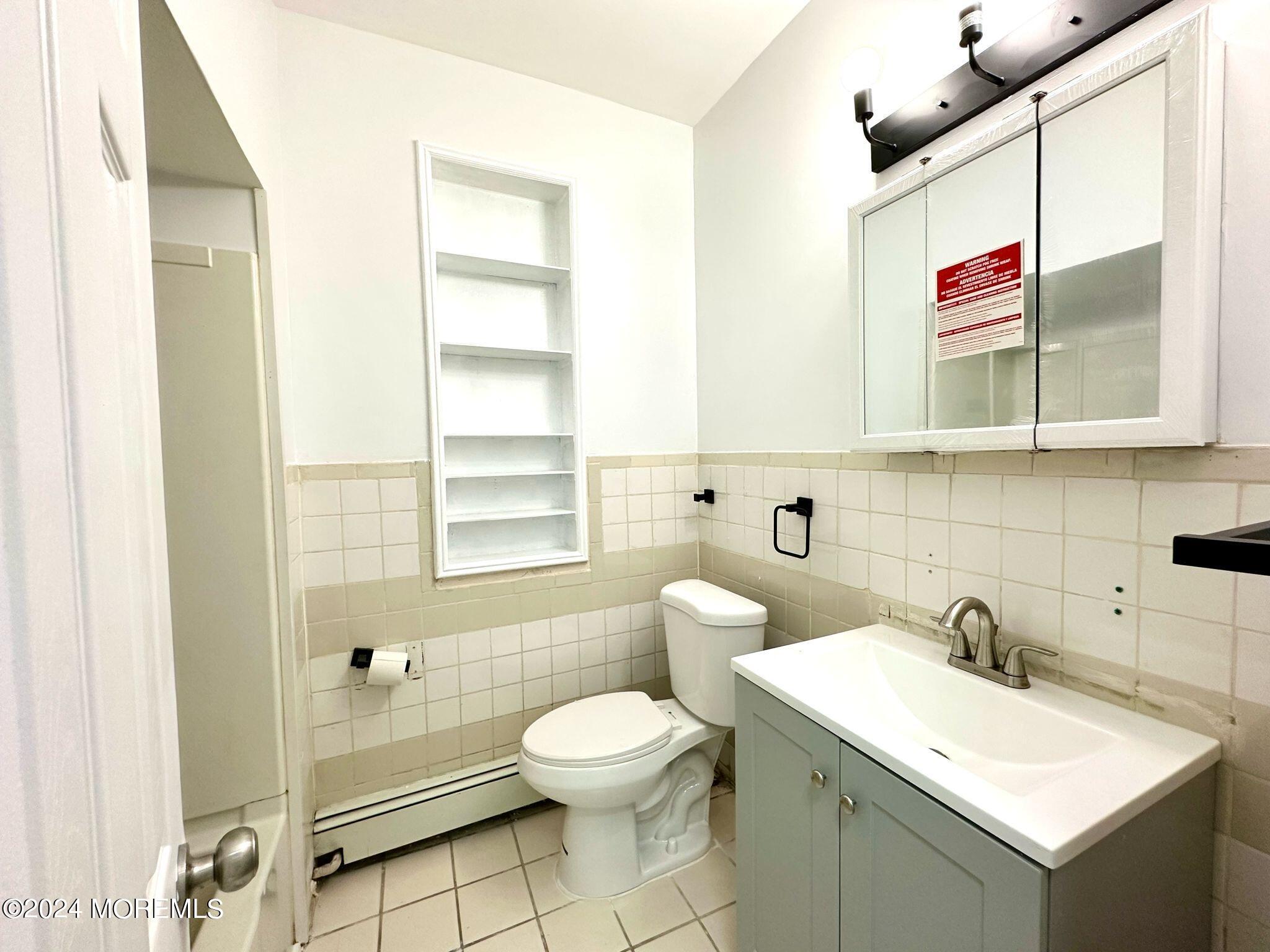 462 Compton Avenue, Unit THIRD Perth Amboy, NJ 08861 - Photo 8 of 14 a bathroom with a toilet sink and mirror