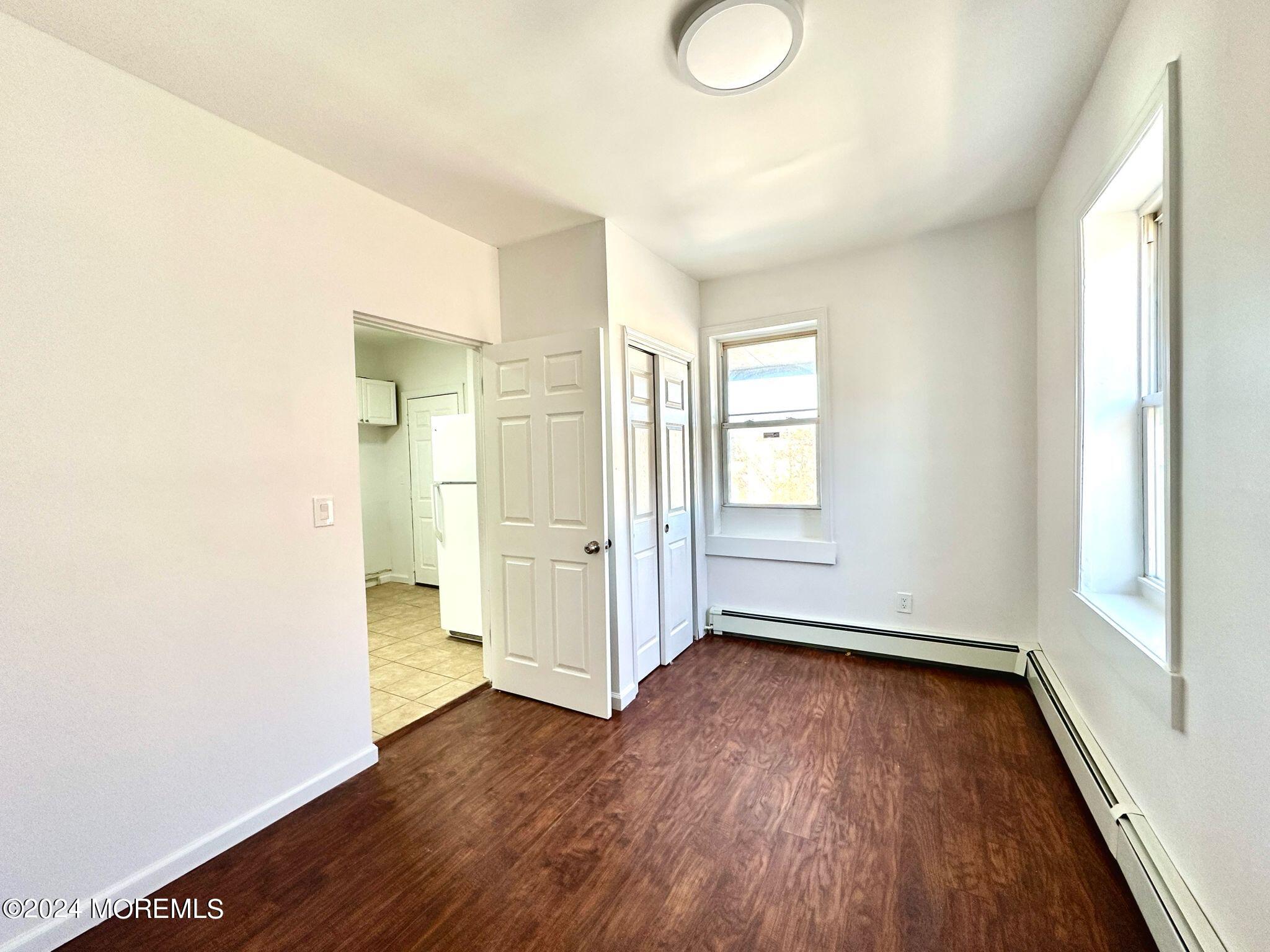 462 Compton Avenue, Unit THIRD Perth Amboy, NJ 08861 - Photo 10 of 14 an empty room with wooden floor and windows