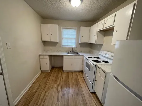 a kitchen with a sink a stove and cabinets
