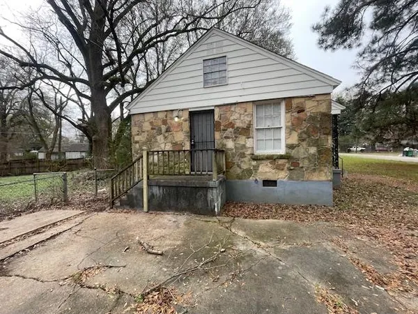a view of a house with backyard and trees