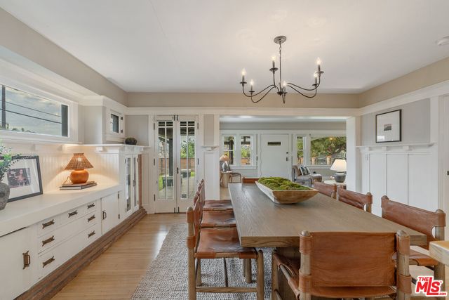 a view of a dining room with furniture a chandelier and wooden floor