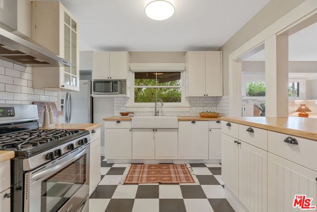 a kitchen with a stove a sink and a window