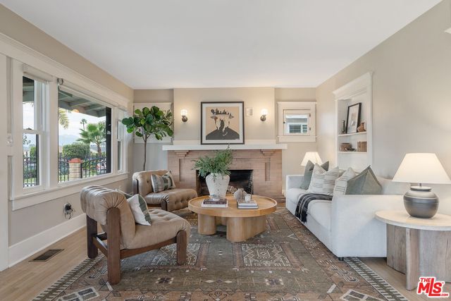 a living room with furniture fireplace and a large window