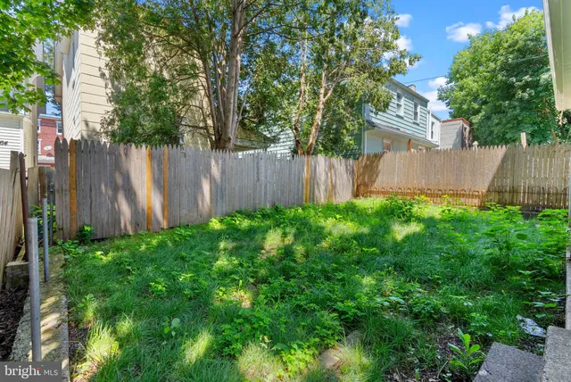 a view of a backyard with potted plants and wooden fence