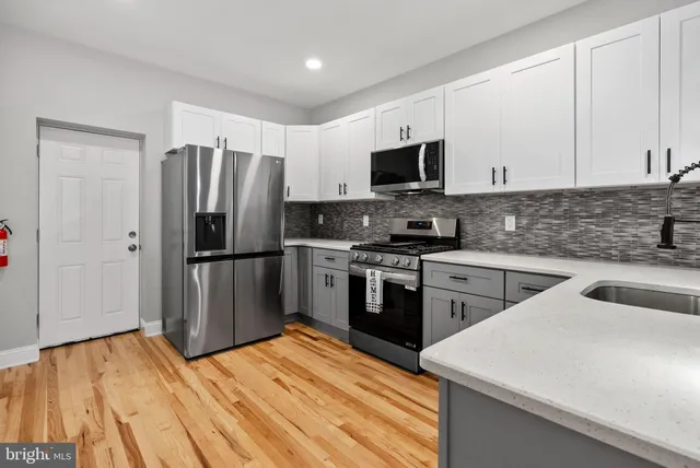a kitchen with granite countertop a refrigerator stove and sink