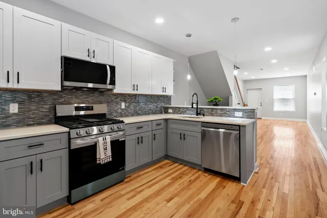 a kitchen with stainless steel appliances granite countertop a stove a sink and a microwave