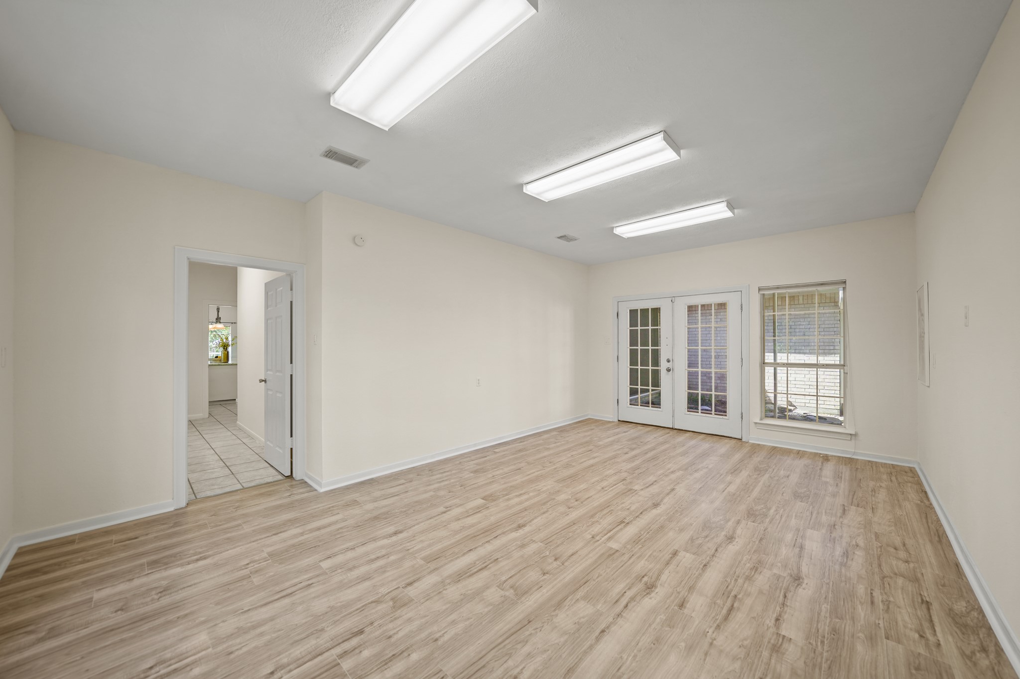 12690 Longmire Way Conroe, TX 77304 - Photo 19 of 50 a view of an empty room with wooden floor and a window