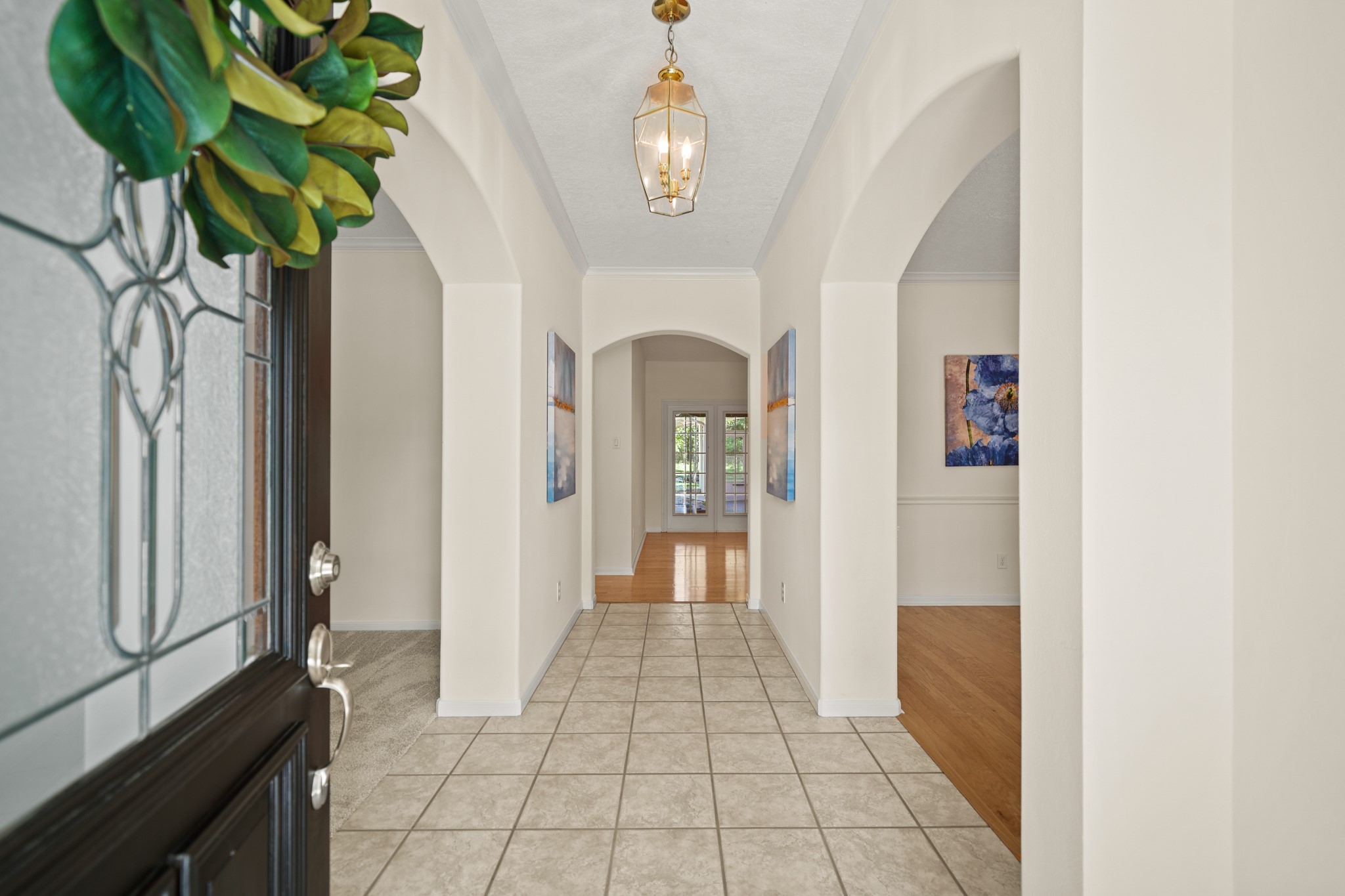 12690 Longmire Way Conroe, TX 77304 - Photo 2 of 50 Charming brick steps with wrought iron hand rails lead to the stately covered front porch supported by decorative columns with space for outdoor furniture. A wood-stained and leaded glass front door with sidelights & transom opens to the foyer of the home.