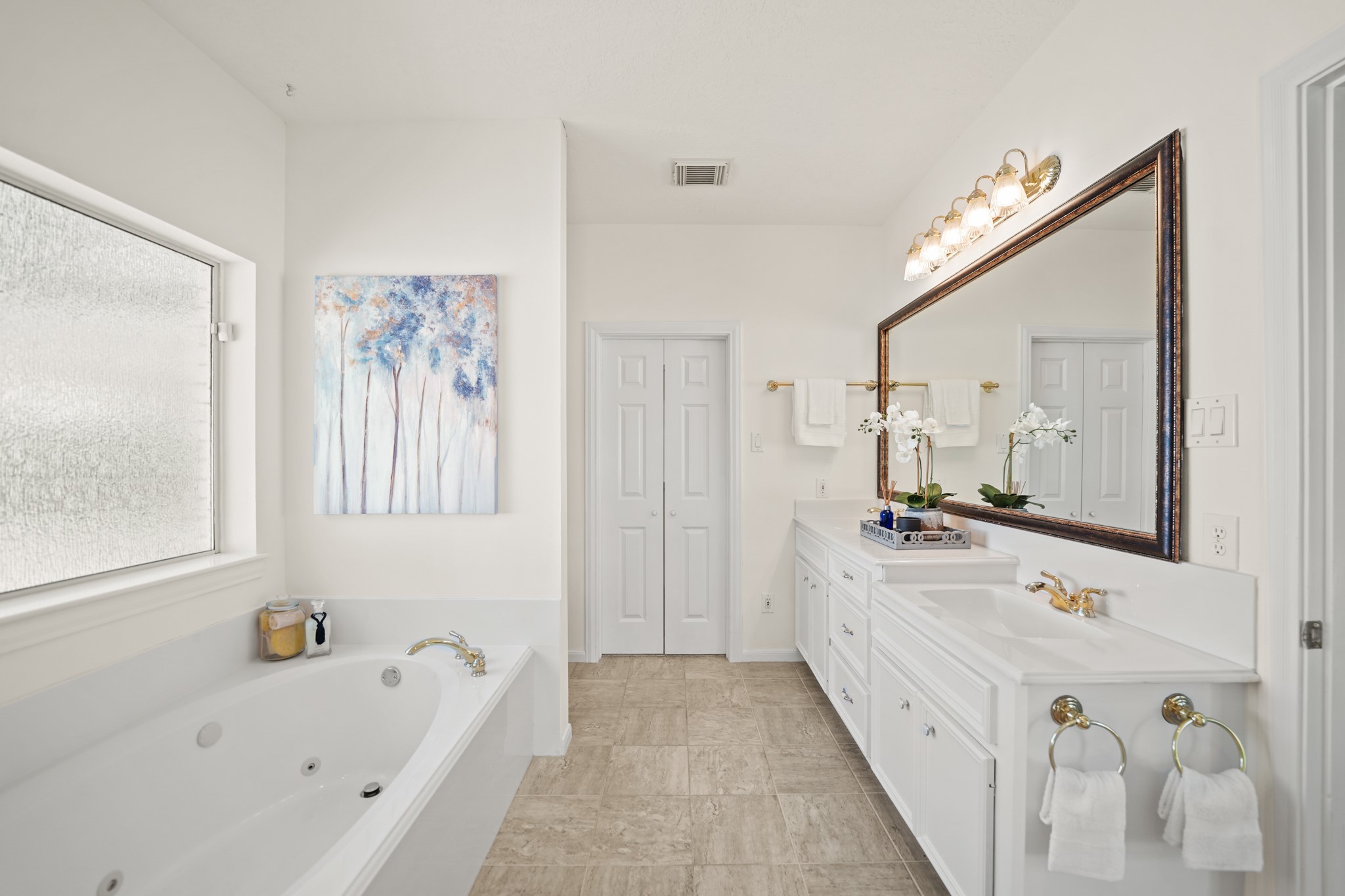 12690 Longmire Way Conroe, TX 77304 - Photo 24 of 50 a bathroom with a tub a double vanity sink and mirror