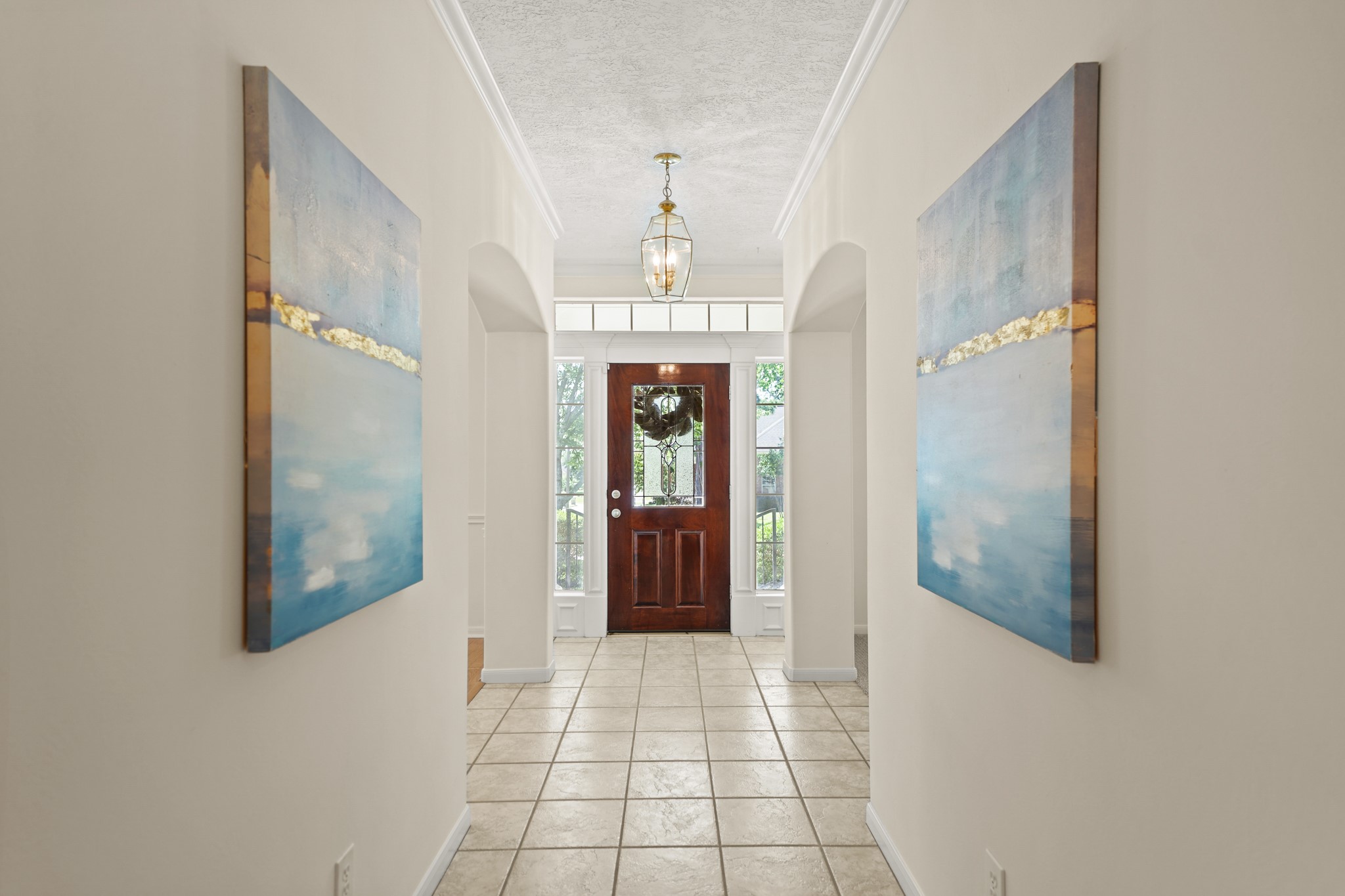 12690 Longmire Way Conroe, TX 77304 - Photo 3 of 50 Features include crown moulding, a hanging light fixture, plenty of space for accent furniture & art work along with ceramic tile flooring. The complete interior of the home was repainted in 2025.