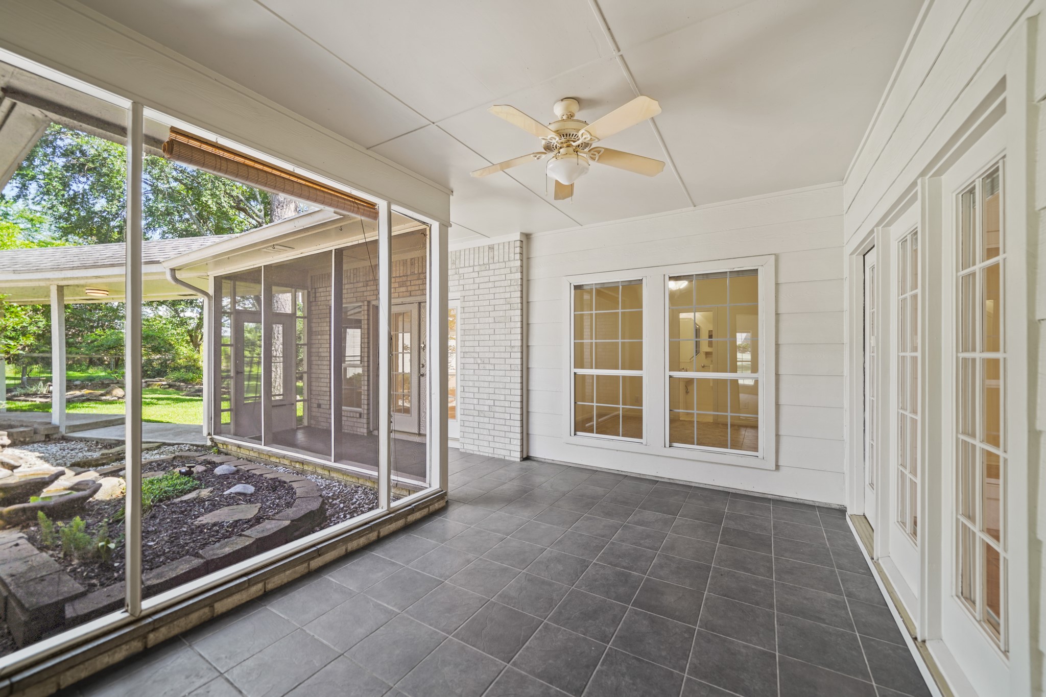 12690 Longmire Way Conroe, TX 77304 - Photo 42 of 50 A view of the backyard & covered walkway leading to the home's 3-car attached garage.