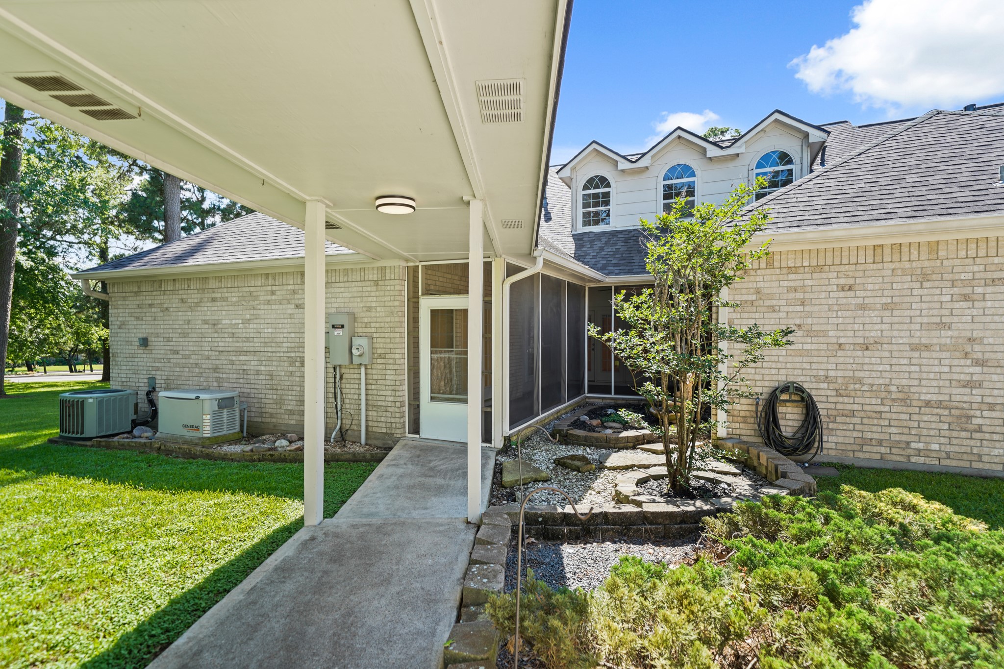 12690 Longmire Way Conroe, TX 77304 - Photo 46 of 50 A view of the back of the home from the garage with the whole home generator system shown on the left.