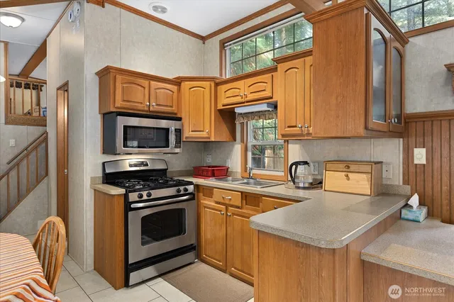 a kitchen with stainless steel appliances granite countertop a stove a sink and a microwave
