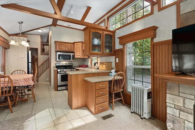 a kitchen with stainless steel appliances granite countertop a stove top oven a sink and a refrigerator