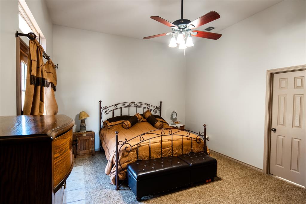 2211 Mc Alpin Road Midlothian, TX 76065 - Photo 13 of 37 a bedroom with a bed and a chandelier