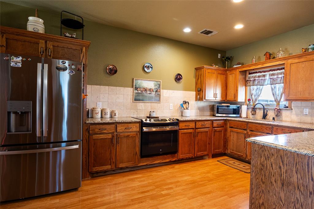 2211 Mc Alpin Road Midlothian, TX 76065 - Photo 27 of 37 a large kitchen with stainless steel appliances granite countertop a stove a sink dishwasher and a refrigerator