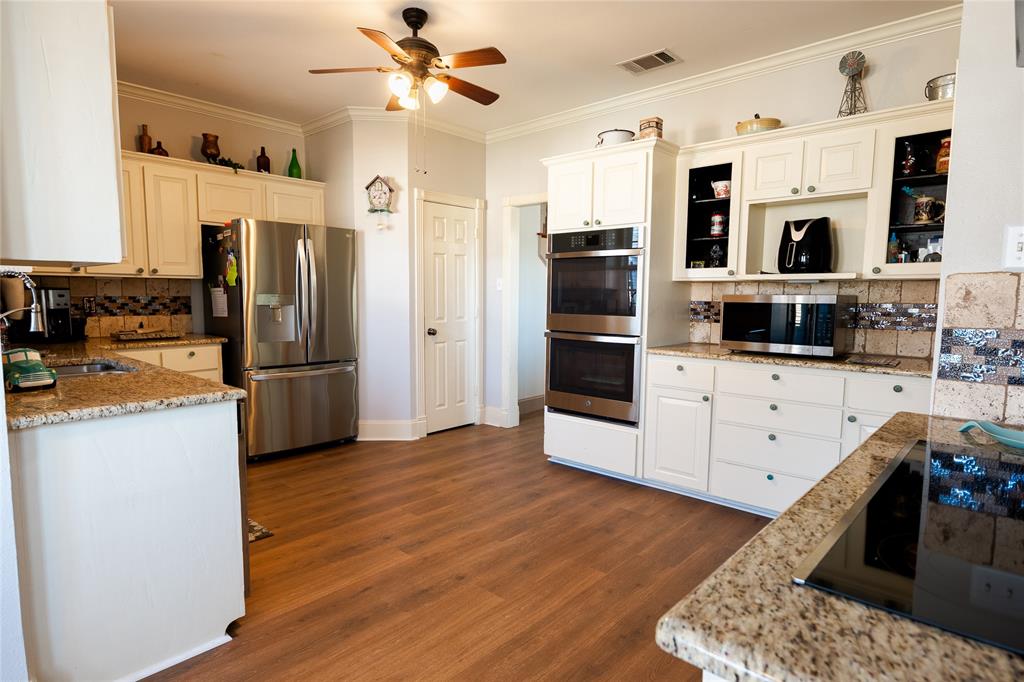 2211 Mc Alpin Road Midlothian, TX 76065 - Photo 7 of 37 a kitchen with stainless steel appliances kitchen island granite countertop a refrigerator and a stove top oven