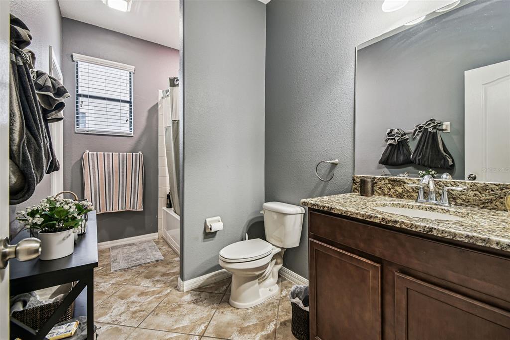 13807 Felix Will Road Riverview, FL 33579 - Photo 38 of 91 a bathroom with a granite countertop toilet sink and mirror