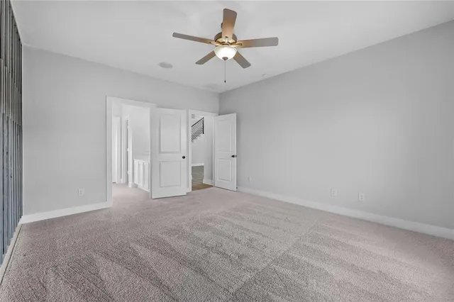 a view of an empty room with a ceiling fan