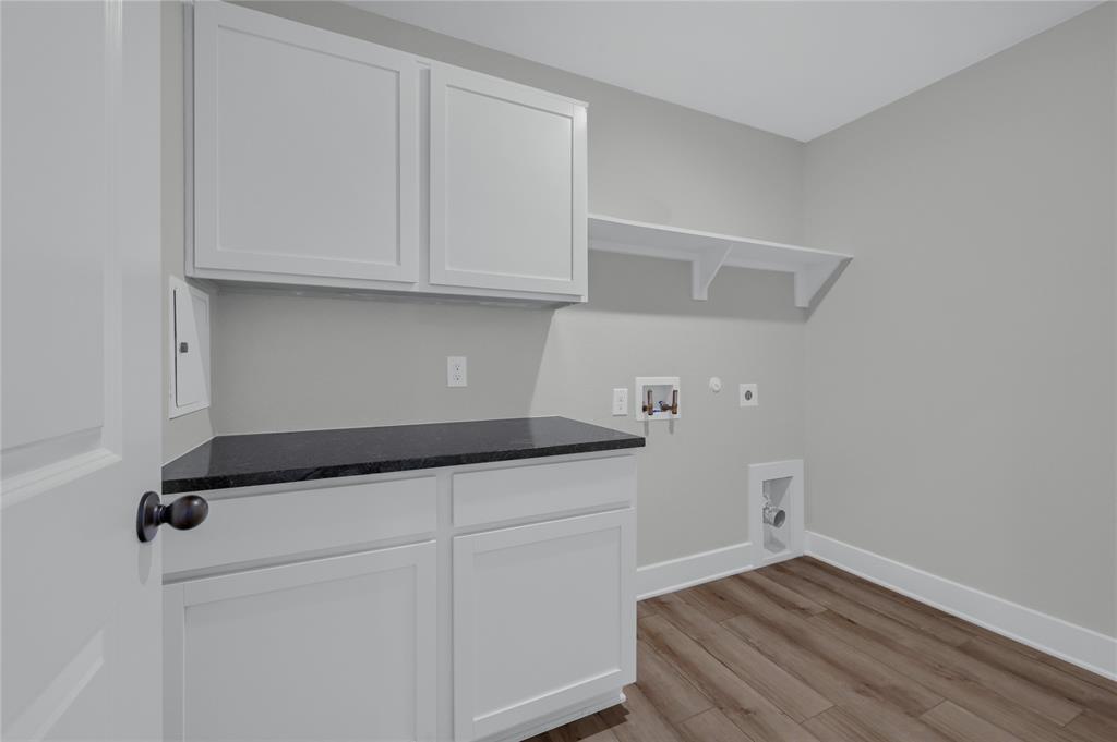 1902 Aleia Cove Sherman, TX 75092 - Photo 15 of 25 a kitchen with granite countertop white cabinets and a wooden floor
