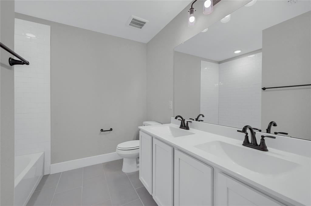 1902 Aleia Cove Sherman, TX 75092 - Photo 21 of 25 a bathroom with a toilet a sink and mirror