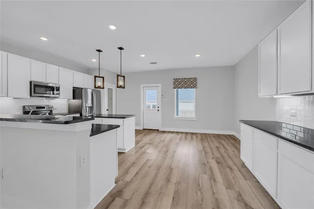 a kitchen with granite countertop a sink stove and refrigerator