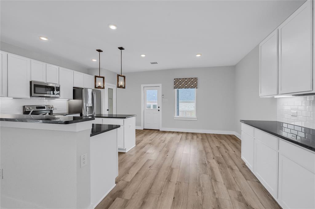 1902 Aleia Cove Sherman, TX 75092 - Photo 7 of 25 a kitchen with granite countertop a sink stove and refrigerator