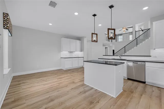 a view of kitchen with stainless steel appliances granite countertop wooden floor sink and window