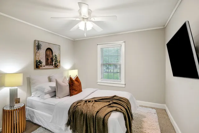 a bedroom with a bed and a flat tv screen on the dresser