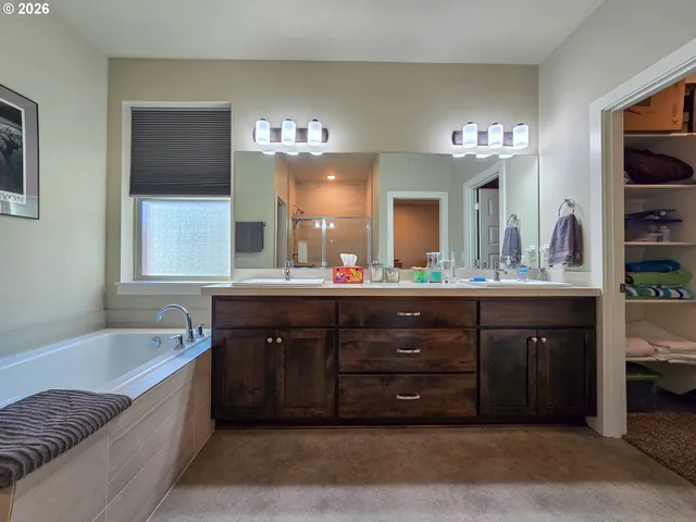 a spacious bathroom with a granite countertop tub double vanity sink and a large mirror