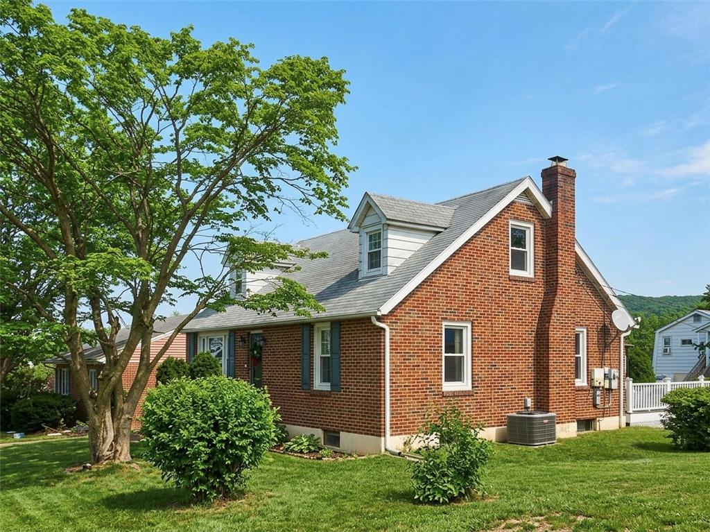 120 Harrison Street Emmaus, PA 18049 - Photo 2 of 2 A charming brick residence awaits, boasting dormer windows and a well-maintained lawn.