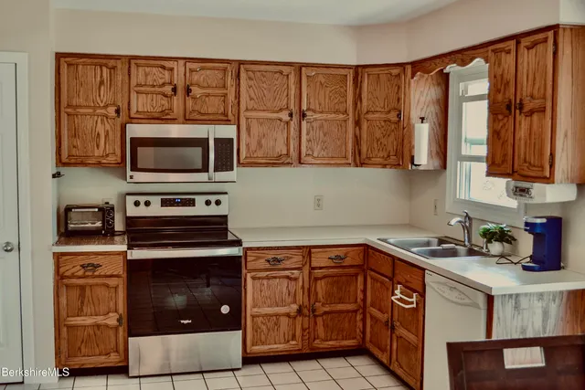 a kitchen with stainless steel appliances granite countertop a stove a sink and a microwave
