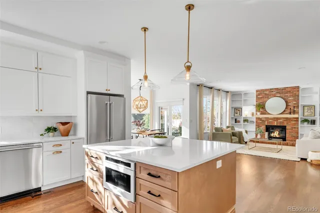 a kitchen with stainless steel appliances granite countertop a sink a stove and a wooden floors