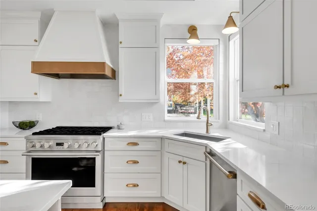 a kitchen with cabinets appliances a sink and a window