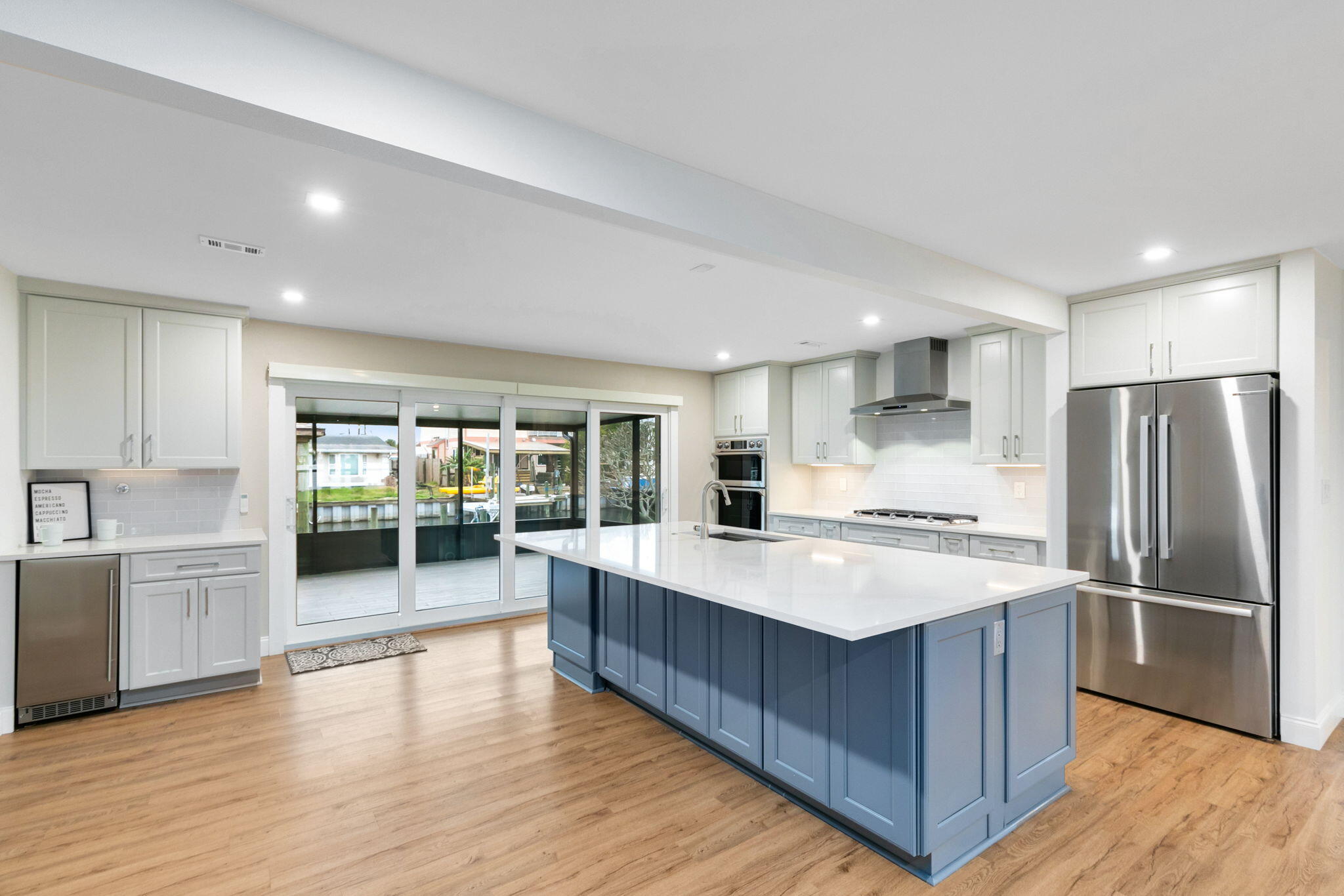 1700 Rochelle Parkway Merritt Island, FL 32952 - Photo 8 of 35 a large kitchen with stainless steel appliances granite countertop a large counter top a stove a sink dishwasher and a refrigerator with wooden floor