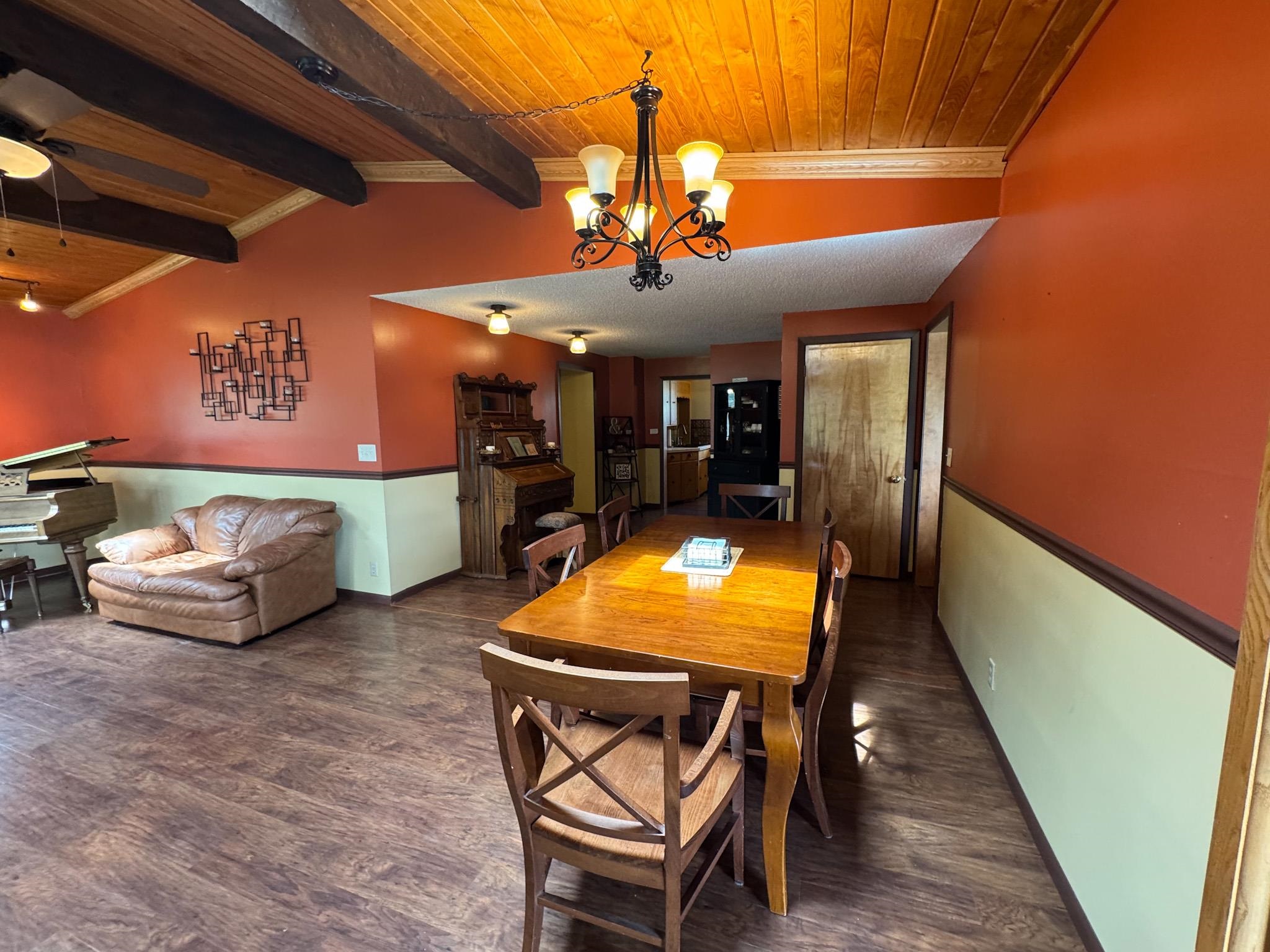 201 Golf Course Lane Bigfork, MN 56628 - Photo 4 of 30 Dining space featuring wooden ceiling, wood finished floors, a chandelier, ceiling fan, and baseboards